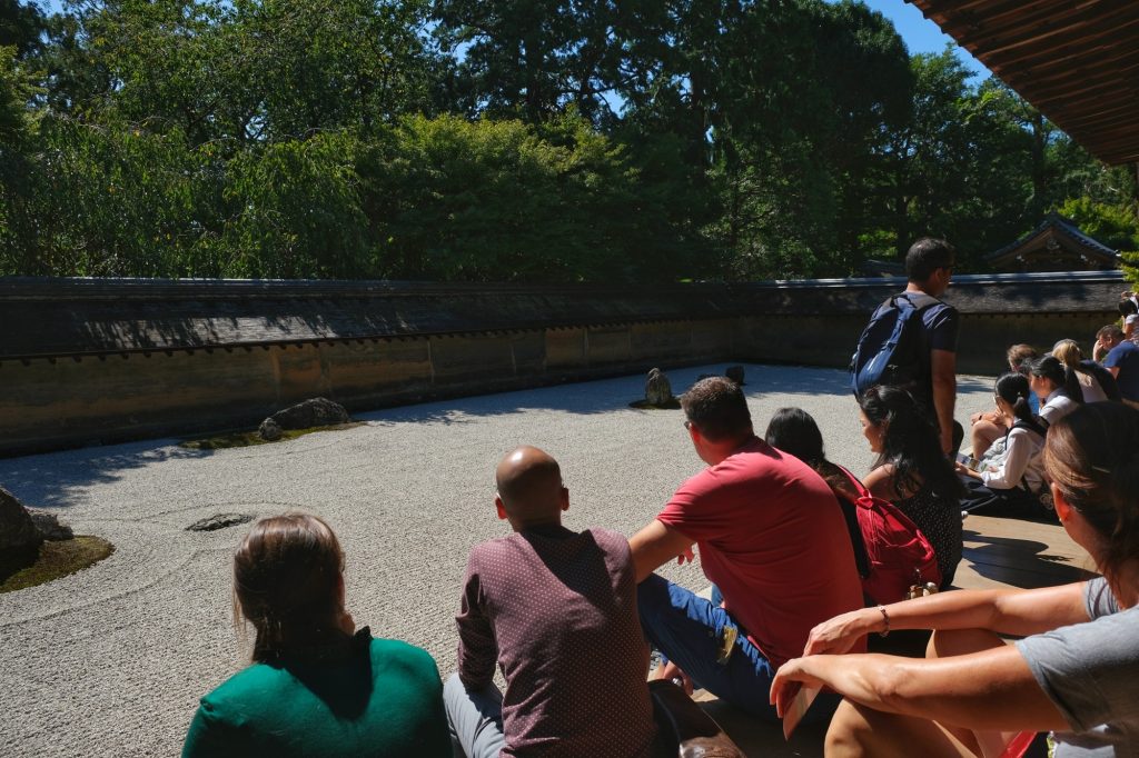 Les touristes méditent devant le jardin zen du Ryoan-ji