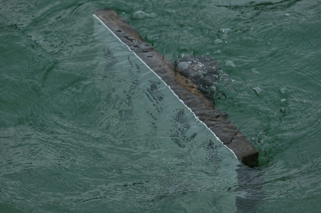 Un panneau immergé à marée haute près du torii de Miyajima