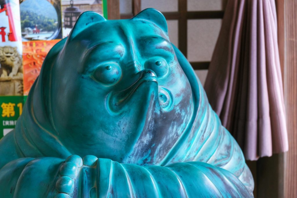 Un tanuki imposant (raton laveur) dans un temple de Miyajima
