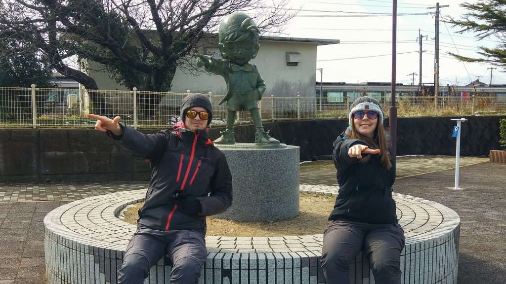 Claire et Vincent devant une statue du détective Conan