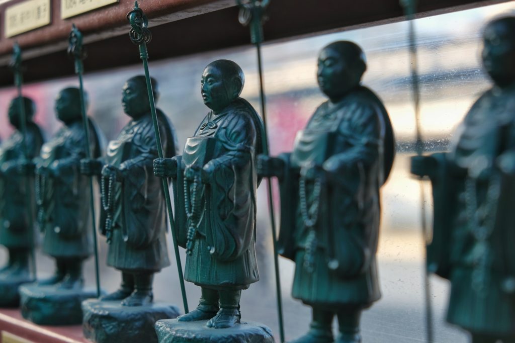 Des mini statuettes de moines devant le Shi Tennoji