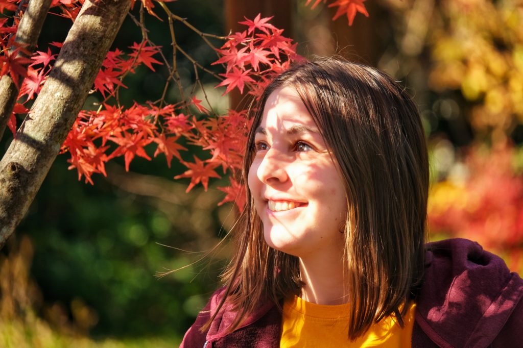 Claire contemple les feuilles rouges du jardin japonais du parc Daisen à Sakai