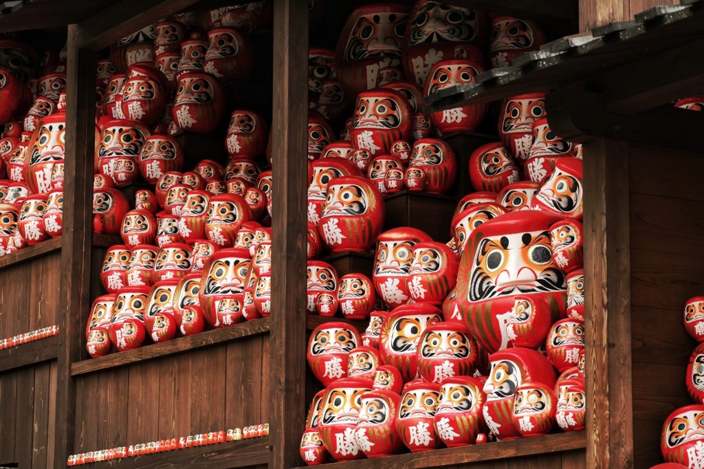 Un étalage de daruma de toutes tailles devant les escaliers du Katsuo-ji