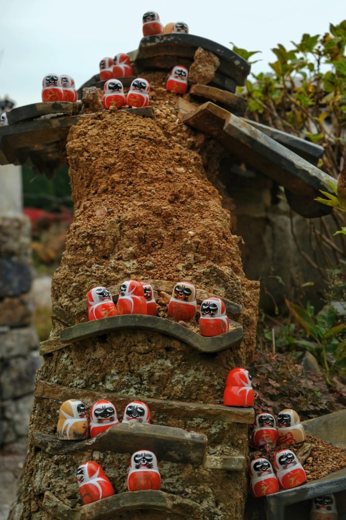 Un muret rongé mais conquis par les daruma au temple Katsuo-ji