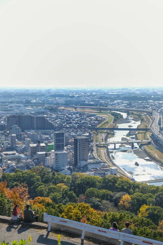 Des promeneurs se reposent devant la rivière Ina et la plaine d'Osaka