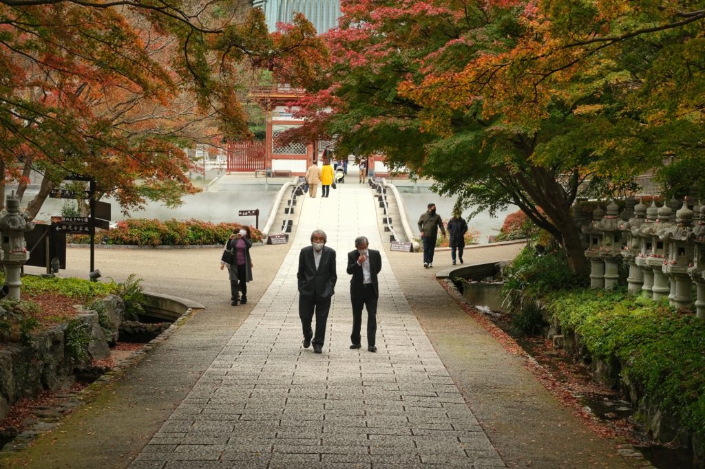 Des salary-men dans l'allée centrale du Katsuo-ji sous les arbres d'automne