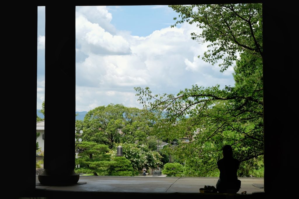 Une personne assise sous la porte Sanmon du Chin-in à Kyoto